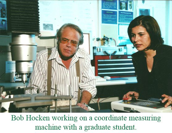 Bob Hocken working on a coordinate measuring machine with a graduate student