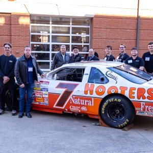 Kulwicki 1992 team members and Niner Engineer motorsports students with championship car at Kulwicki Lab