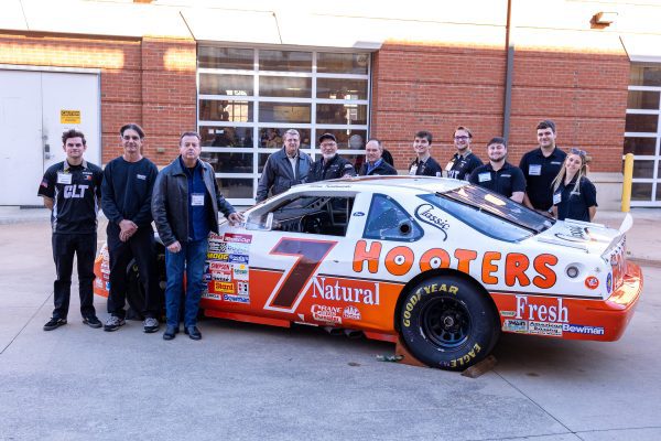 Kulwicki 1992 team members and Niner Engineer motorsports students with championship car at Kulwicki Lab