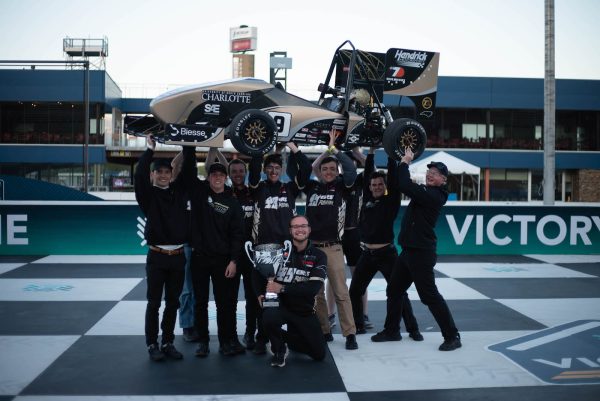 49ers Racing team members hoist winning race car in the air