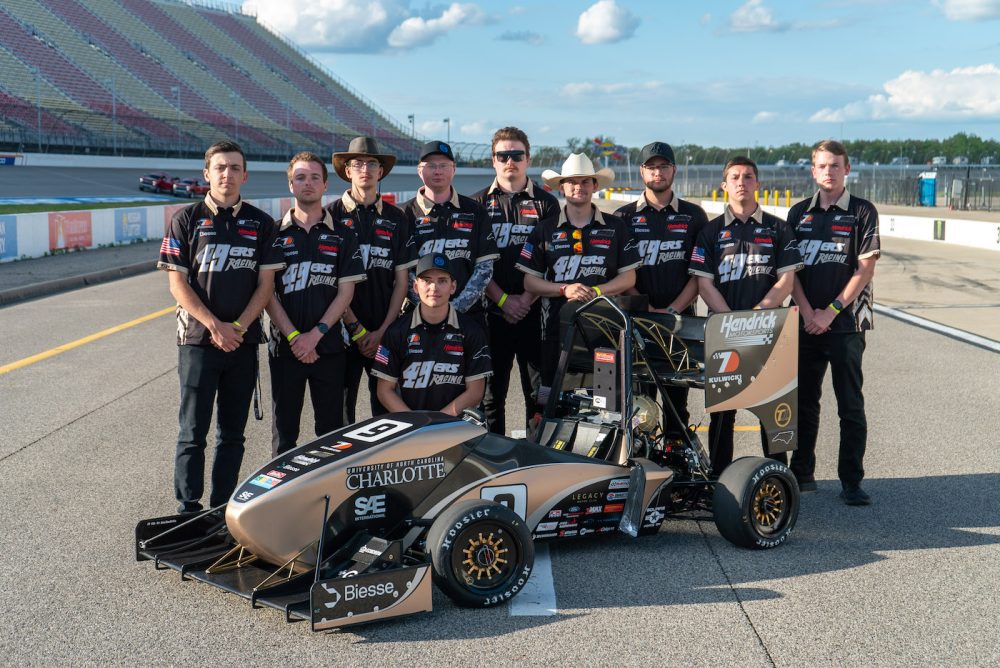 49ers Racing team members stand behind racecra