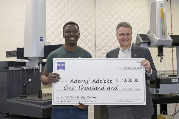 Adeniyi Adeleke holds check with Ed Morse, Director of the Center for Precision Metrology